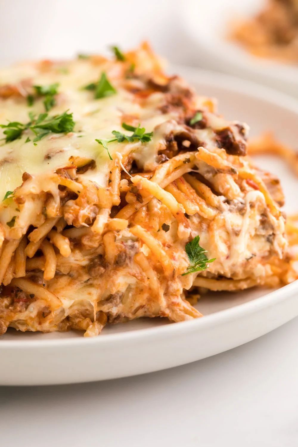 A serving of baked spaghetti with meat sauce and melted mozzarella cheese